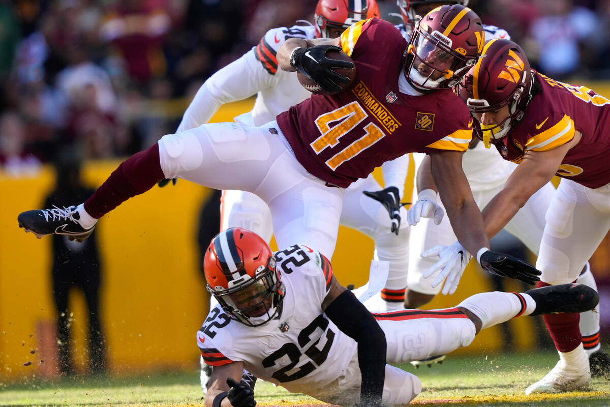 Cleveland Browns safety Grant Delpit (22) tackles Washington Commanders running back Jonathan W ...