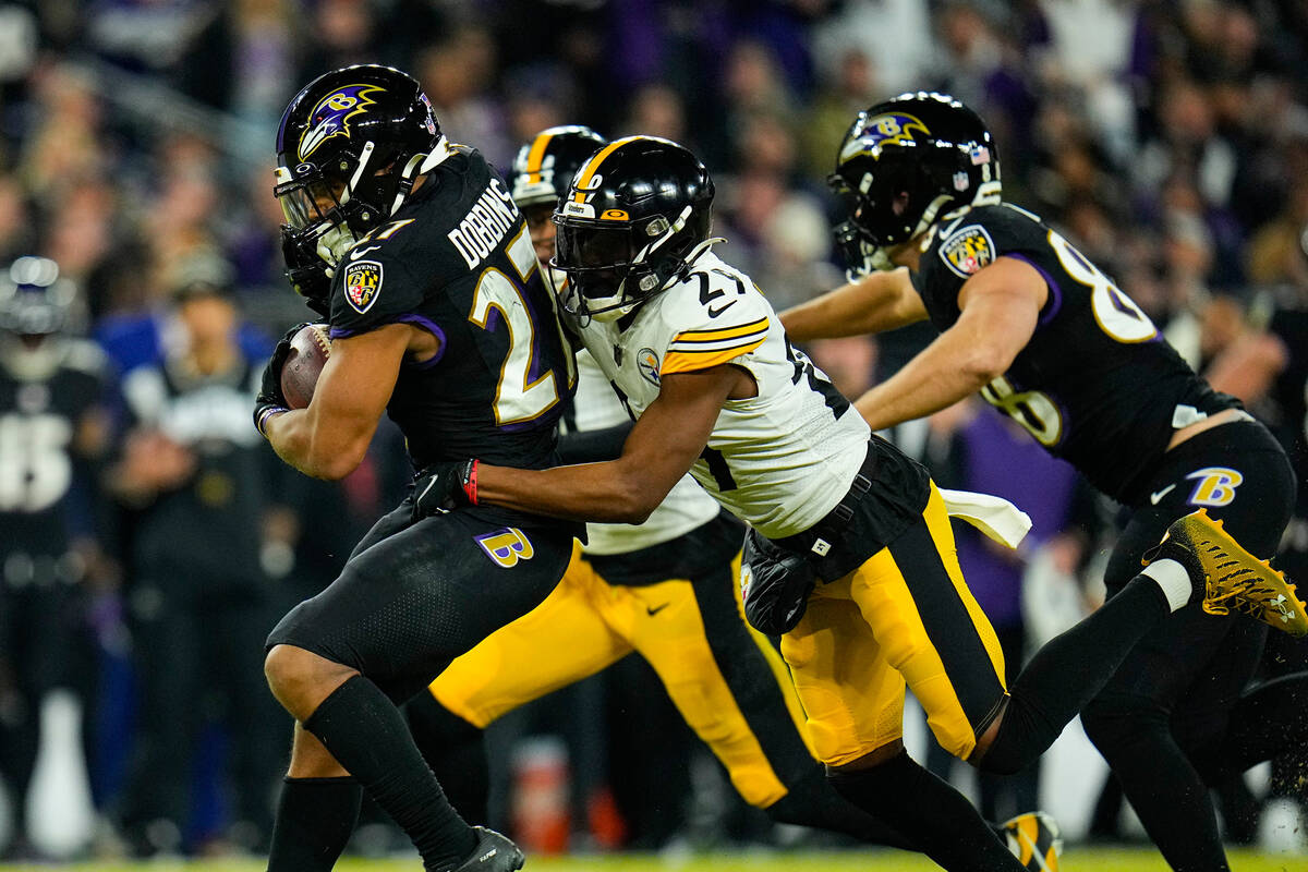 Baltimore Ravens running back J.K. Dobbins (27) is tackled by Pittsburgh Steelers cornerback Le ...