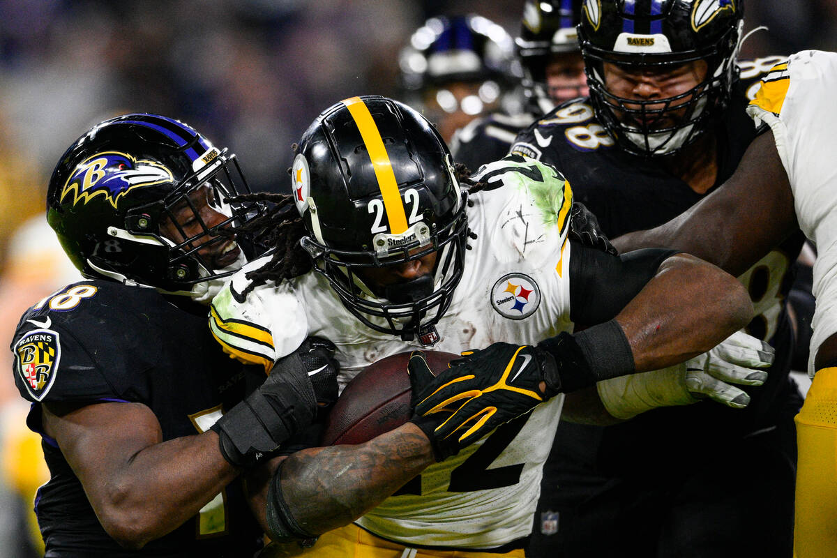 Pittsburgh Steelers running back Najee Harris (22) is tackled by Baltimore Ravens linebacker Ro ...