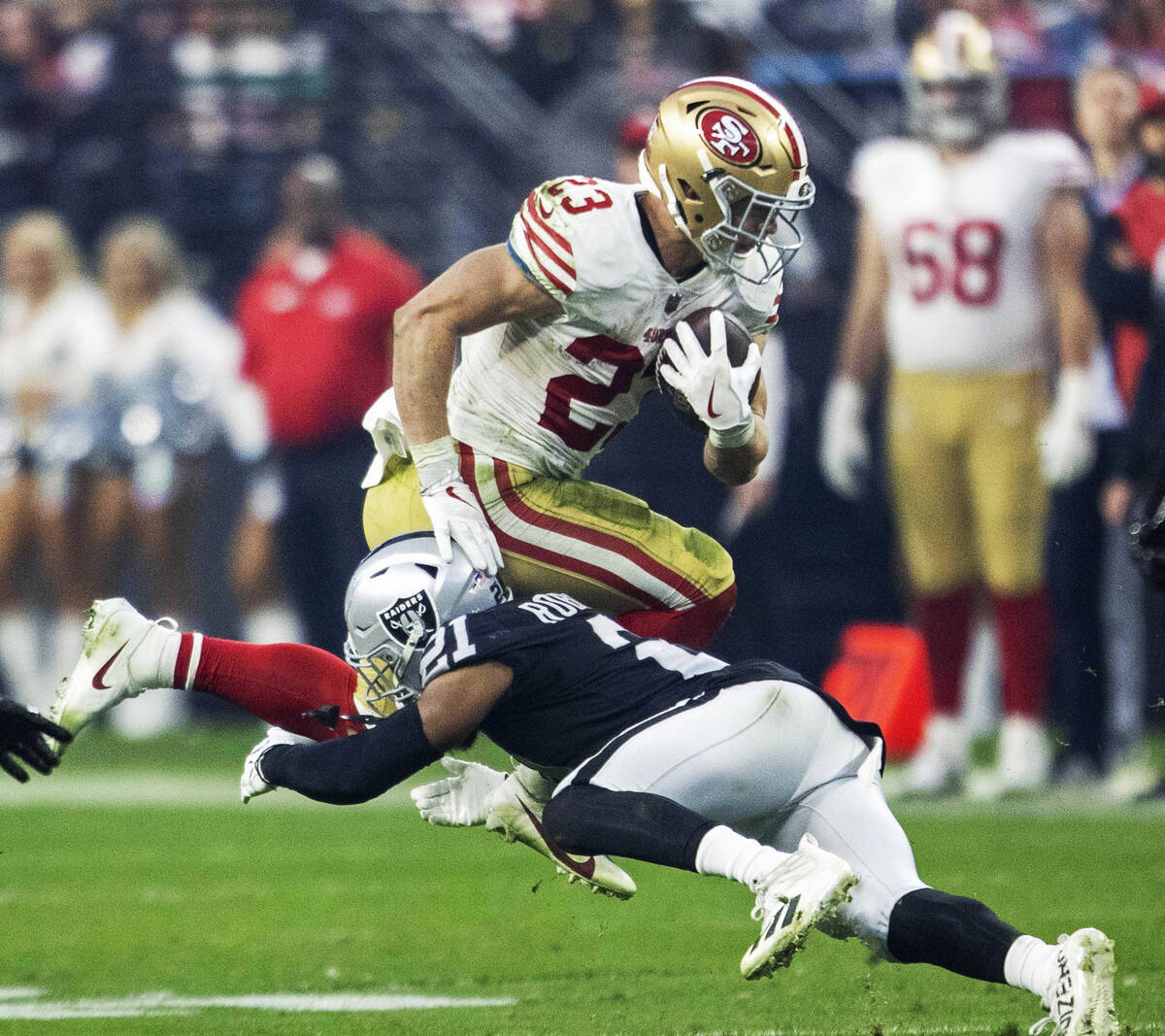 San Francisco 49ers running back Christian McCaffrey (23) hurdles Raiders cornerback Amik Rober ...