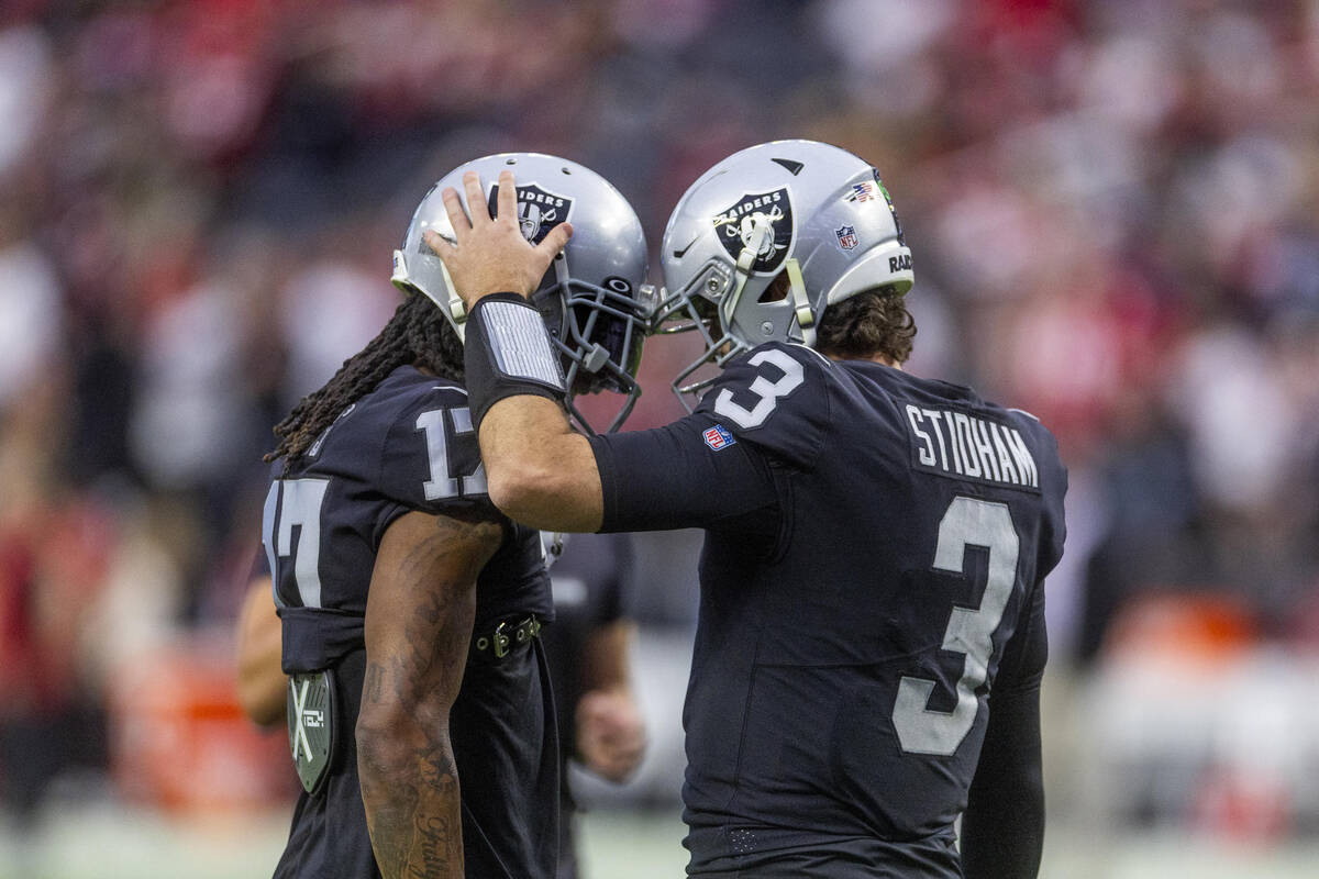 Raiders wide receiver Davante Adams (17) and quarterback Jarrett Stidham (3) have a conversatio ...