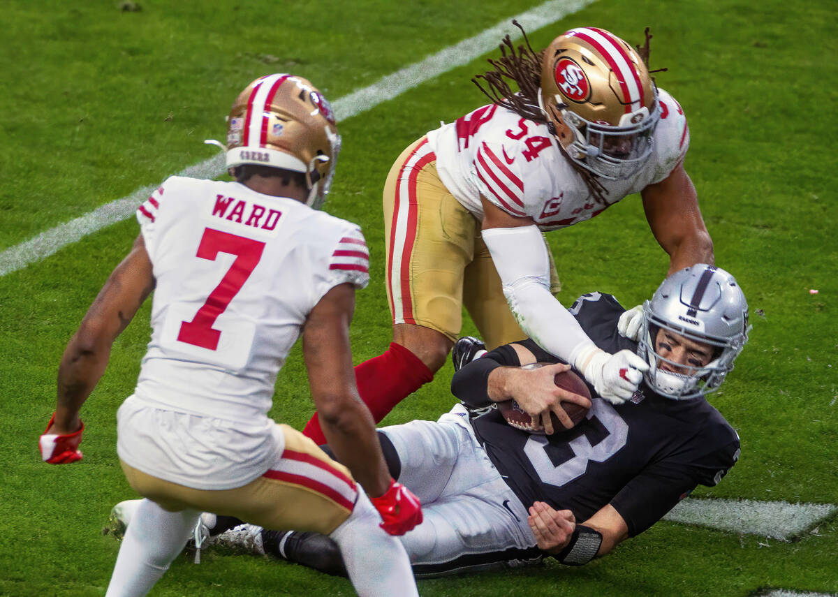 Raiders quarterback Jarrett Stidham (3) is punched on the chin as he slides after a run by San ...