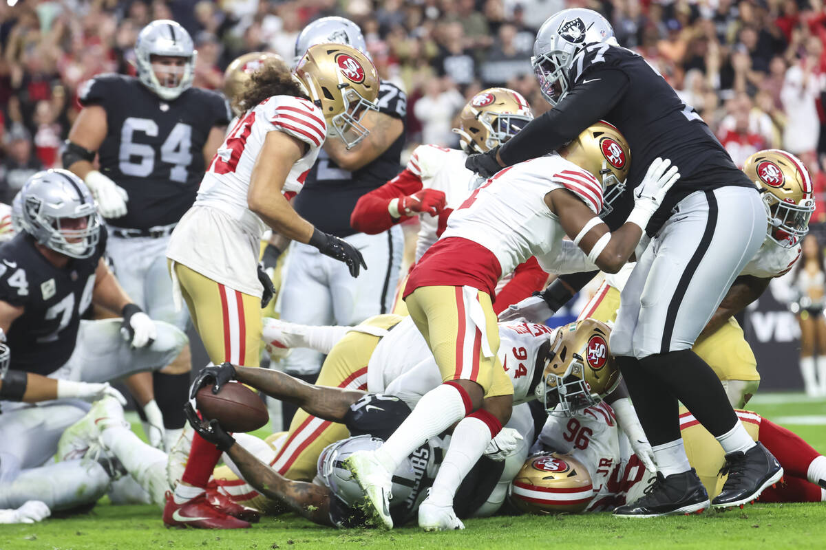 Raiders running back Josh Jacobs (28) gets stopped on the fourth down by the San Francisco 49er ...