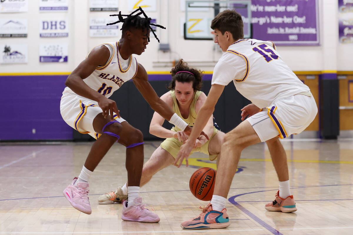 Foothill's Caleb Rhea (15) fights for a loose ball against Durango's Tylen Riley (10) and Aleks ...