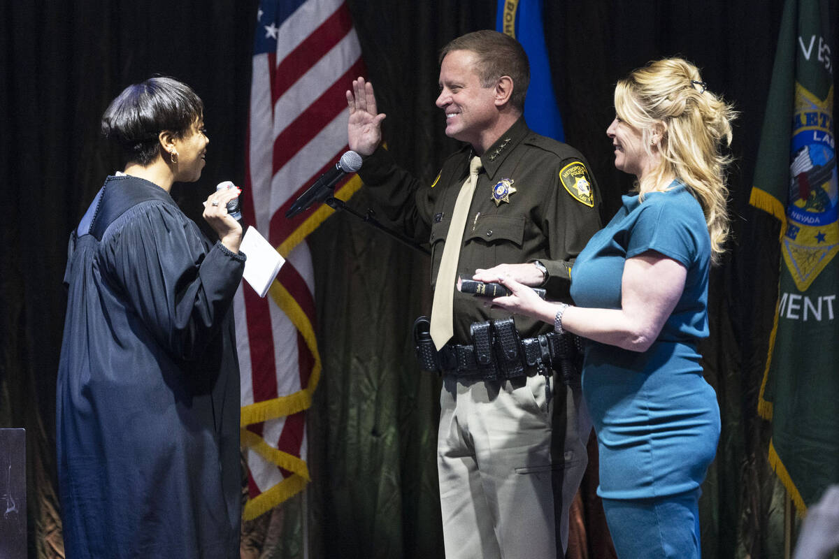 Sheriff Kevin McMahill raises his arm as he is sworn in by Judge Tierra Jones as LVMPD Sheriff ...