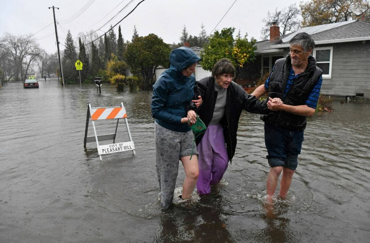 Nurse Katie Leonard, left, assists Scott Mathers, right, as they rescue Mathers' mother, Patsy ...