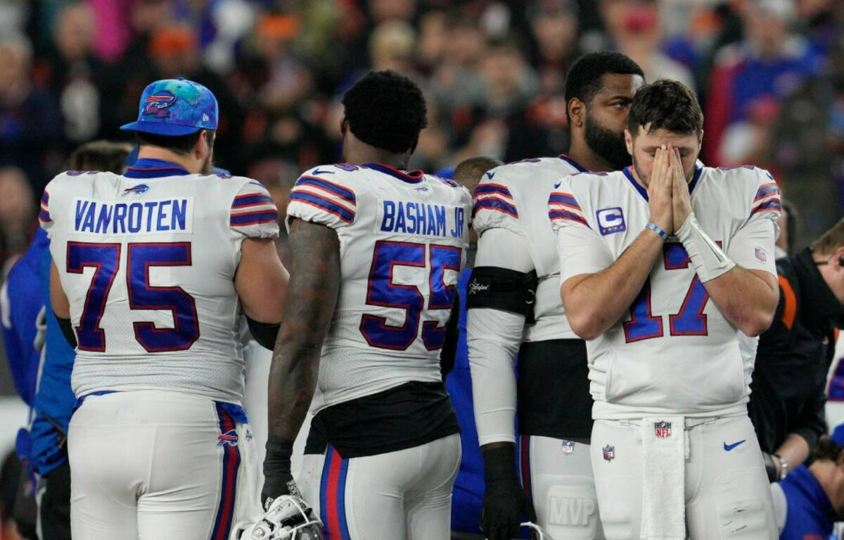 Buffalo Bills quarterback Josh Allen (17) pauses as Damar Hamlin is examined during the first h ...