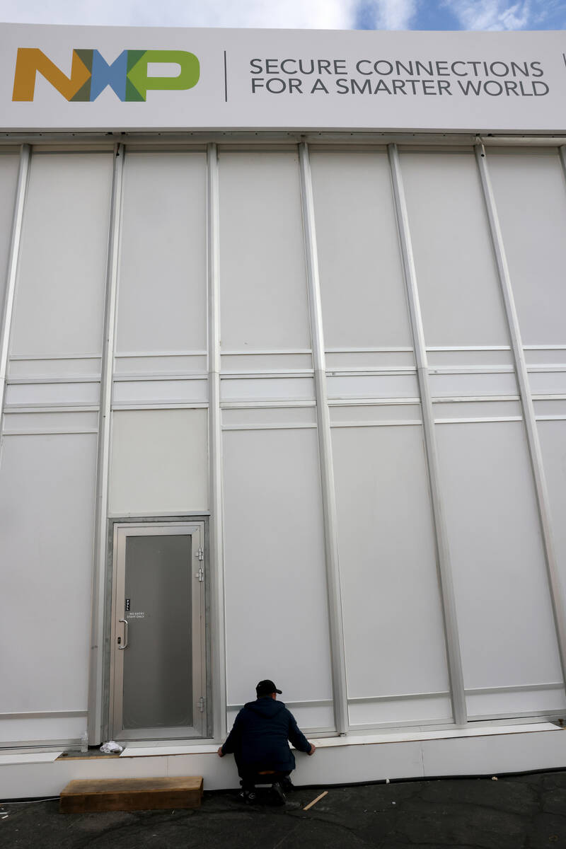 A worker builds an outdoor booth for CES at the Las Vegas Convention Center Tuesday, Jan. 3, 20 ...