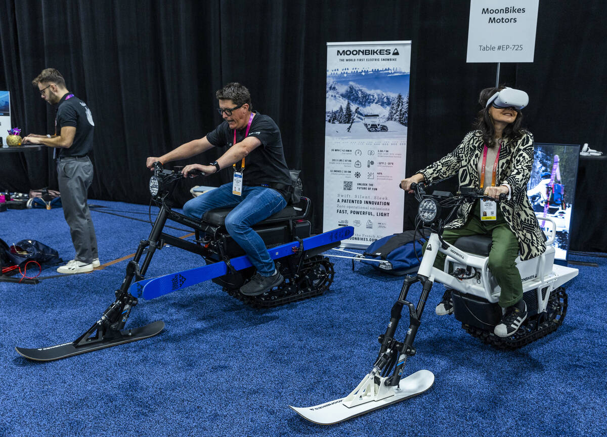 Pete Woman and Gaelle Van Hieu check out a pair of MoonBikes during the CES Unveiled media days ...