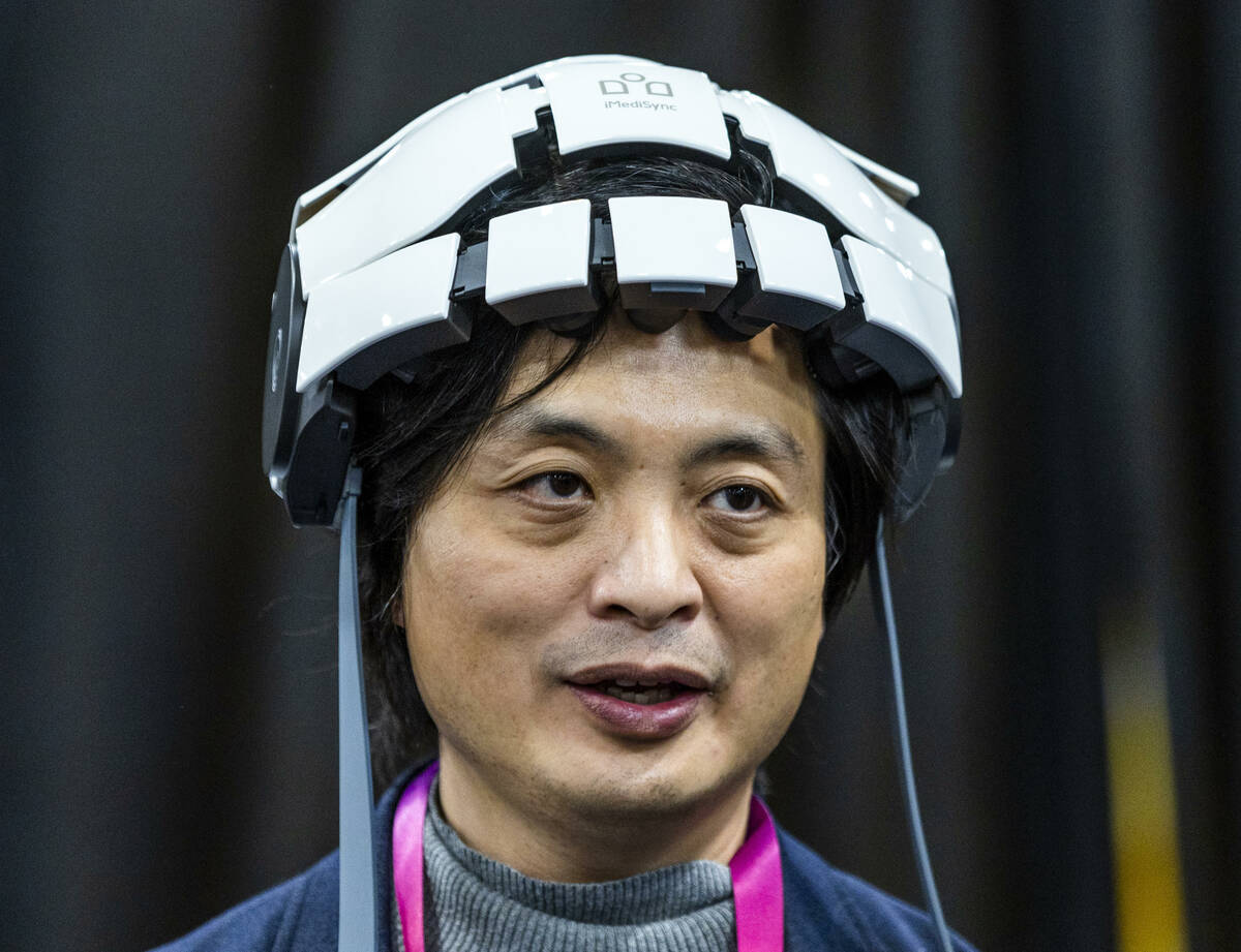 Dr. Seung Wan Kang demonstrates an iSyncWave EEG Brain Scanner during the CES Unveiled media da ...