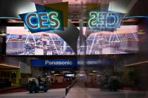 A worker drives down a hallway during preparations at the Las Vegas Convention Center before th ...