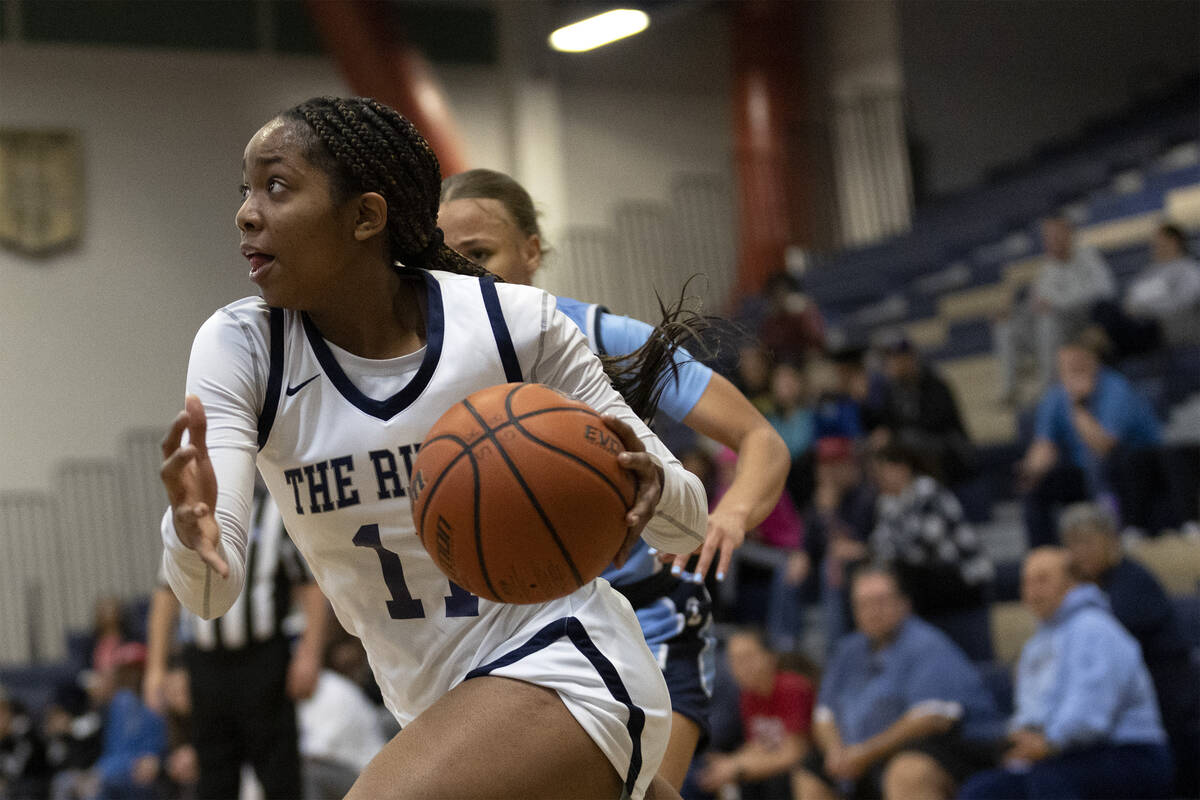 Shadow Ridge’s Hannah Hayes (11) drives toward the hoop during a girls high school baske ...