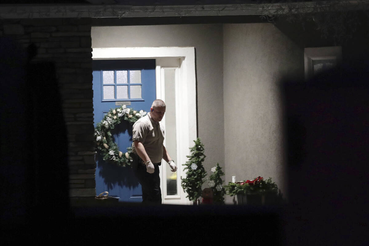A law enforcement official stands near the front door of the Enoch, Utah, home where eight fami ...