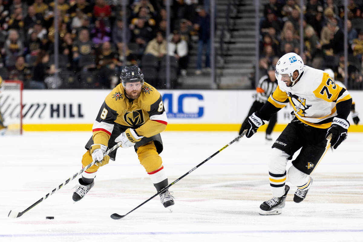 Vegas Golden Knights center Phil Kessel (8) skates with the puck next to Pittsburgh Penguins de ...