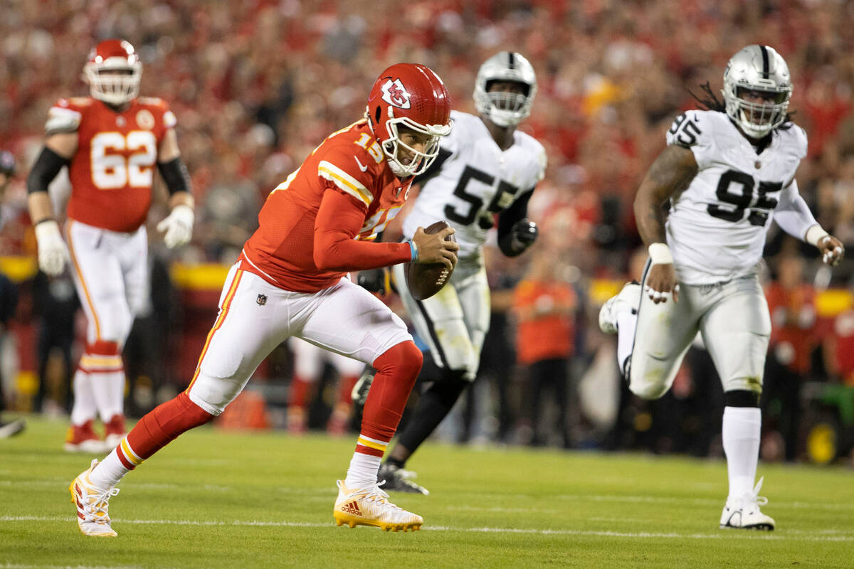 Kansas City Chiefs quarterback Patrick Mahomes (15) rushes with the football with Raiders defen ...