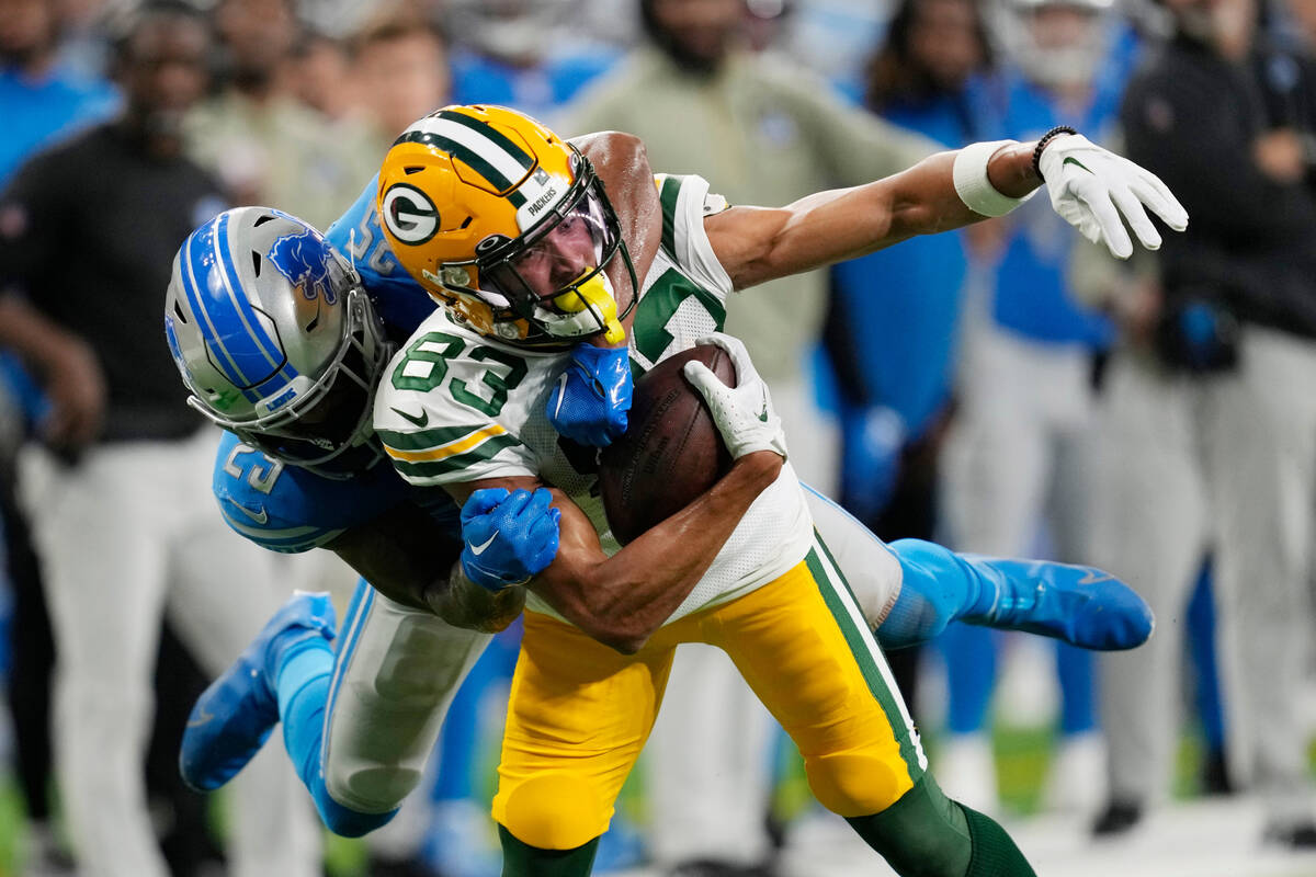 Green Bay Packers wide receiver Samori Toure (83) is tackled by Detroit Lions safety Will Harri ...