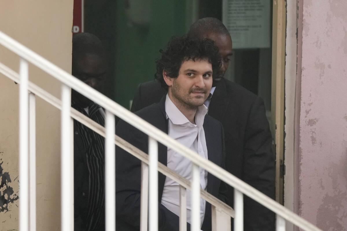 FTX founder Sam Bankman-Fried, is escorted from the Magistrate Court in Nassau, Bahamas, Wednes ...