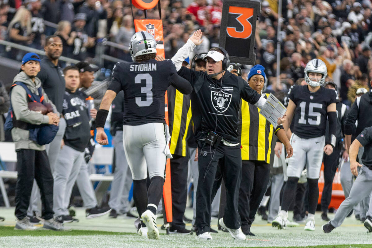 Raiders head coach Josh McDaniels prepares to congratulate Raiders quarterback Jarrett Stidham ...