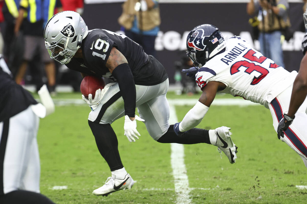 Raiders wide receiver DJ Turner (19) runs the ball past Houston Texans safety Grayland Arnold ( ...