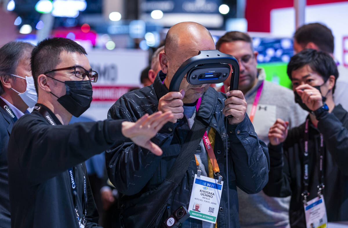 Daisuke Wakamiya with Canon USA guides attendee Kiyotaka through their MREAL virtual system dur ...