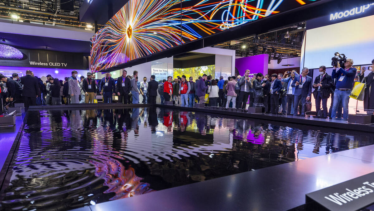 Attendees check out a vibrant LG projection system display in the central hall during the openi ...