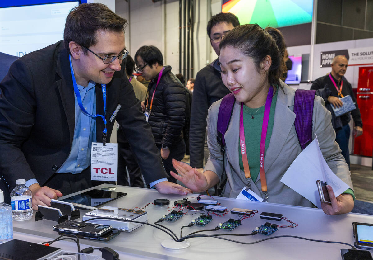 Markus Obermayr with TDK talks about electrical components with attendee Seul Ah Nam during the ...