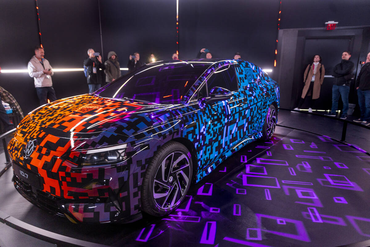 Attendees check out the Volkswagen ID.7 Electric Sedan with Light-Up Paint during the opening d ...