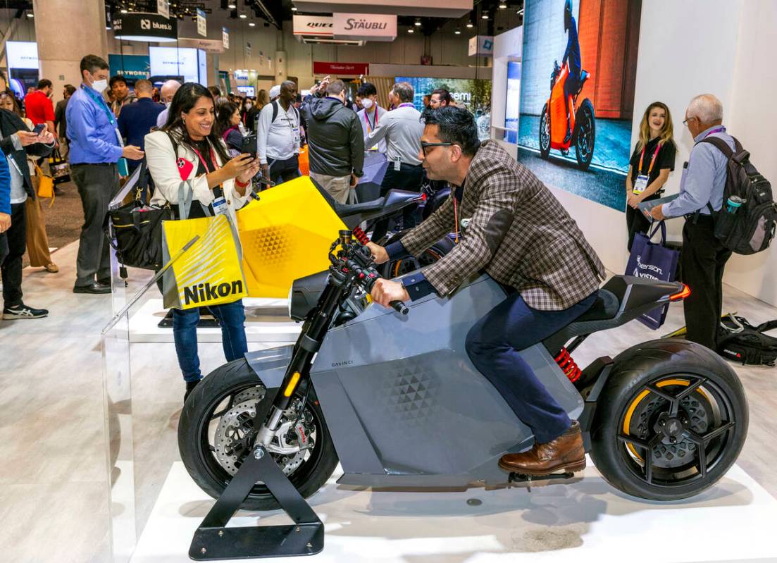 Attendee Neha Gandhi Vijay takes a photo of Usman Zafar as he sits on a Davinci DC100 electric ...