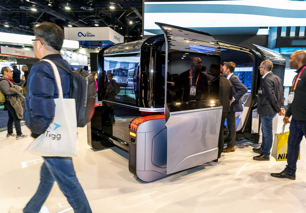 Attendees check out a Italdesign Climb-E fully autonomous capsule designed for urban use as bot ...