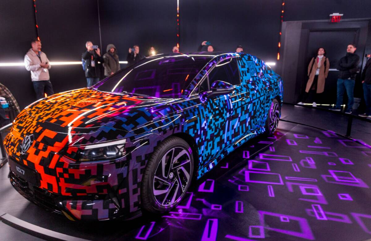Attendees check out the Volkswagen ID.7 Electric Sedan with Light-Up Paint during the opening d ...