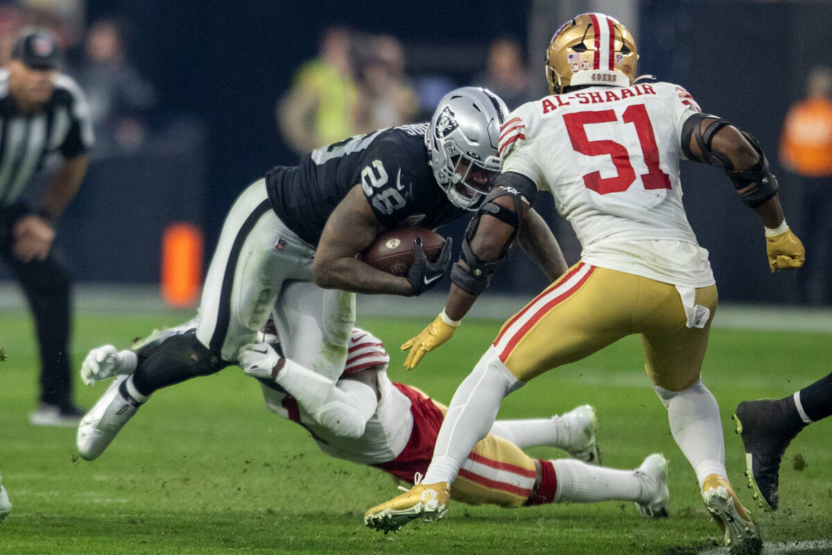 Raiders running back Josh Jacobs (28) divers for yards as he is tackled by San Francisco 49ers ...