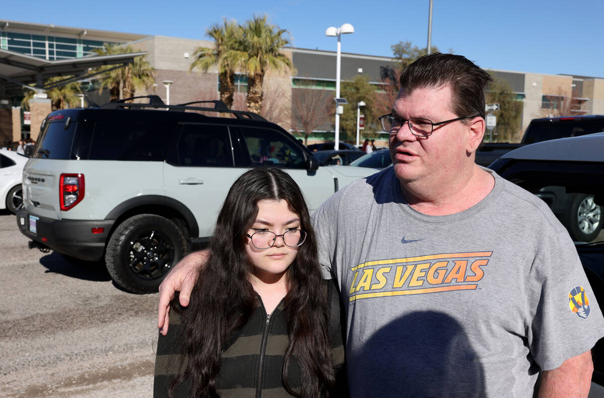Student Alyssa Scharer, 16, and her father, Joel, talk to a reporter after dismissal at Desert ...