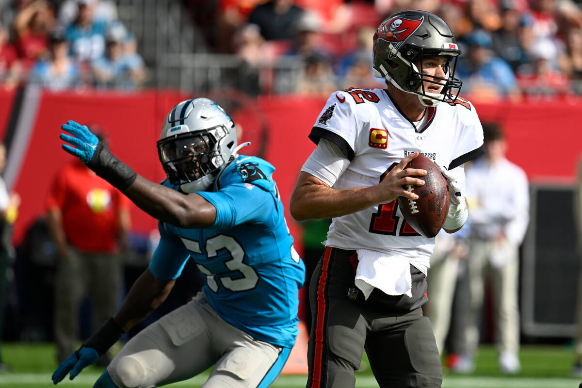 Tampa Bay Buccaneers quarterback Tom Brady (12) eludes Carolina Panthers defensive end Brian Bu ...