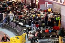 Workers looks for passengers’ luggage from canceled and delayed flights in the Southwest bagg ...
