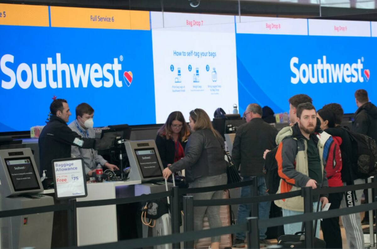 Travelers queue up at the check-in counters for Southwest Airlines in Denver International Airp ...