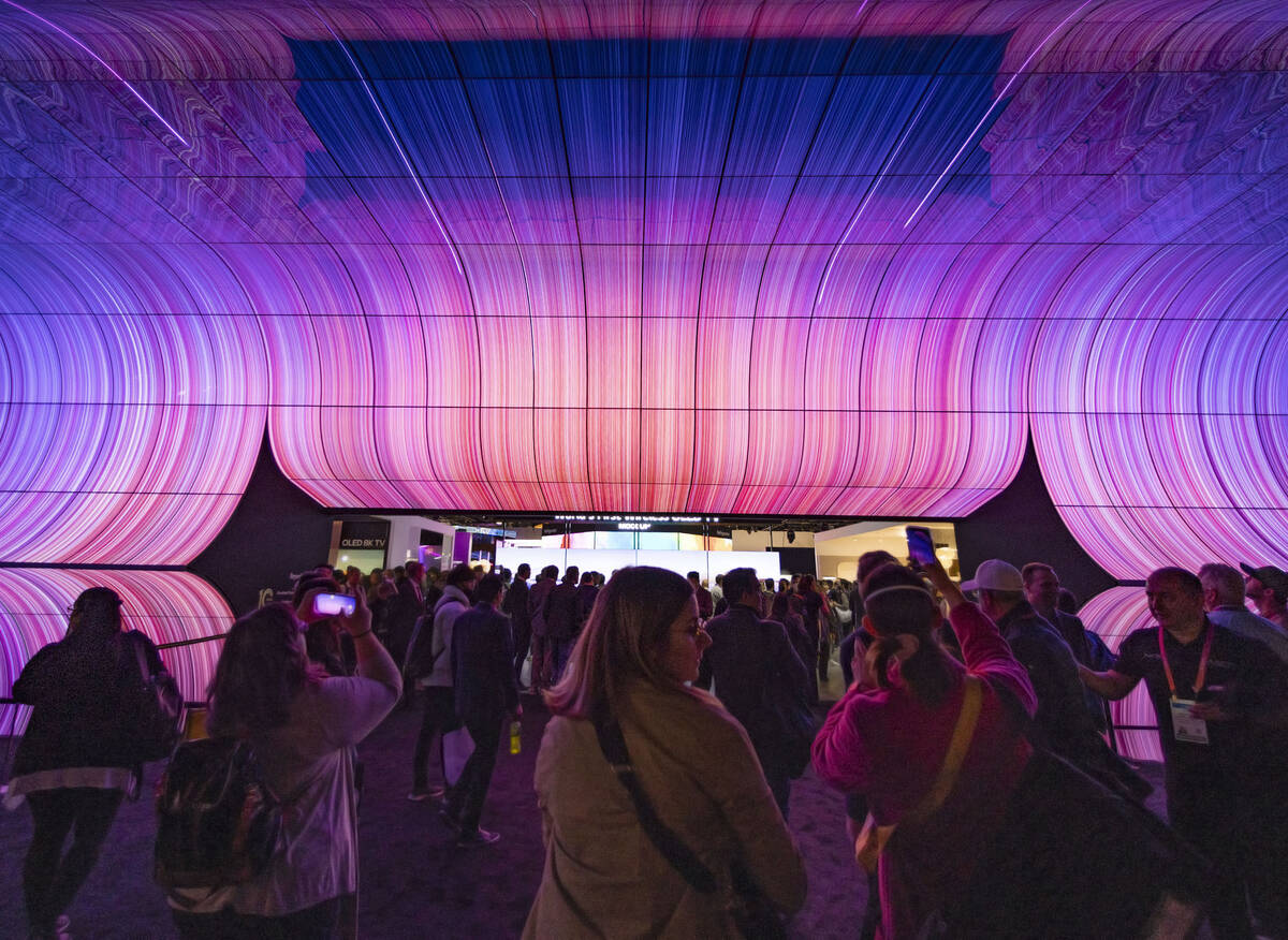 Conventioneers watch special effect on LG world's first wireless flexible OLED screens during ...