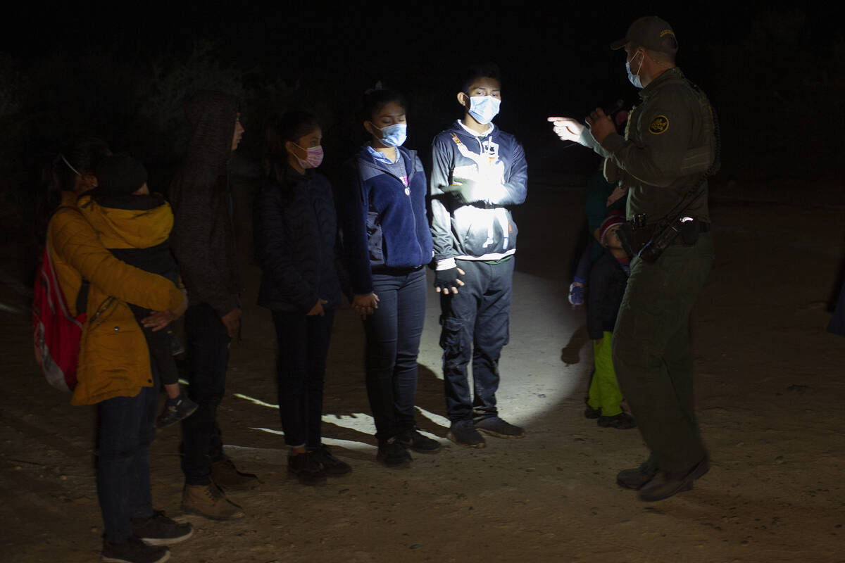 In this March 28, 2021 file photo Migrants from Guatemala and Honduras are questioned by a Bord ...