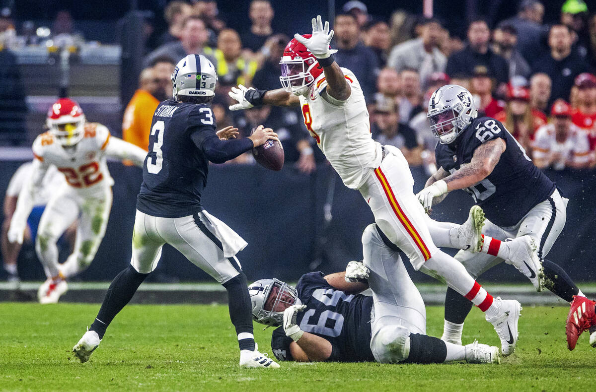 Raiders quarterback Jarrett Stidham (3) looks to unload a pass as Kansas City Chiefs defensive ...