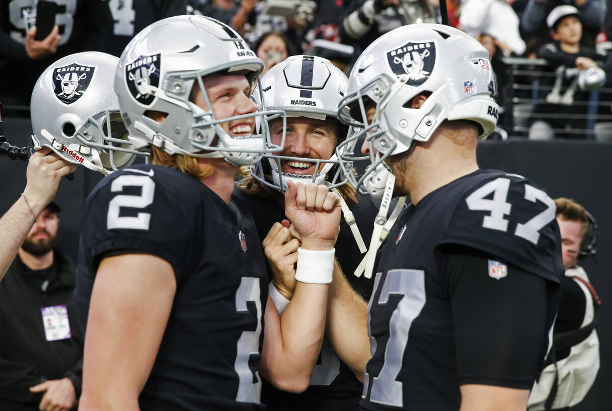 Raiders punter AJ Cole, center, huddles with place kicker Daniel Carlson (2) and long snapper T ...