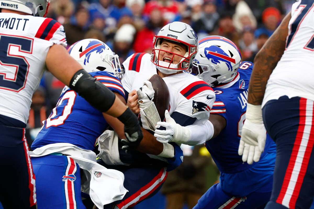New England Patriots quarterback Mac Jones (10) is sacked by Buffalo Bills defensive end Greg R ...