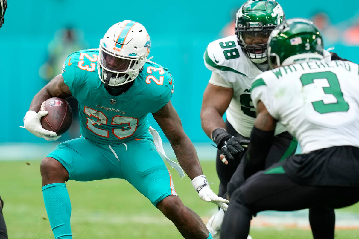 Miami Dolphins running back Jeff Wilson Jr. (23) runs a play during the first half of an NFL fo ...