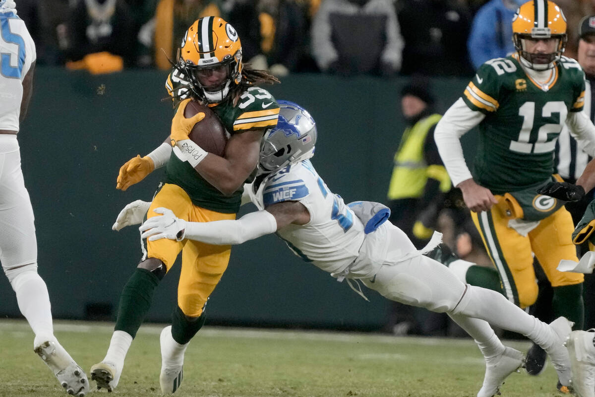 Green Bay Packers running back Aaron Jones (33) runs with the ball as Detroit Lions cornerback ...