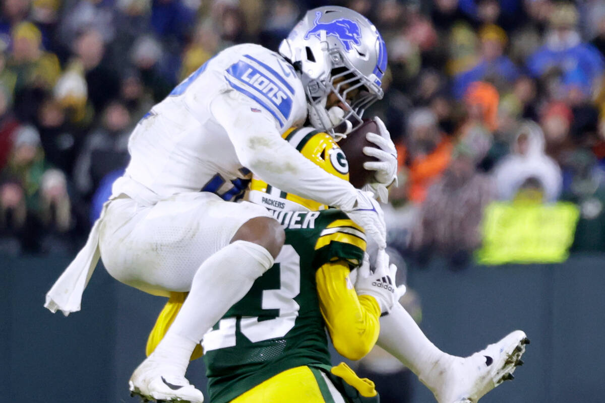 Detroit Lions running back D'Andre Swift attempts to hurdle Green Bay Packers cornerback Jaire ...