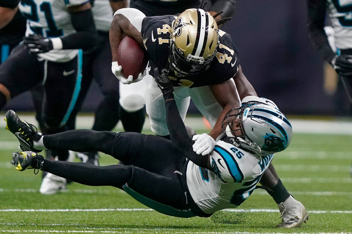 New Orleans Saints running back Alvin Kamara is tackled by Carolina Panthers safety Xavier Wood ...