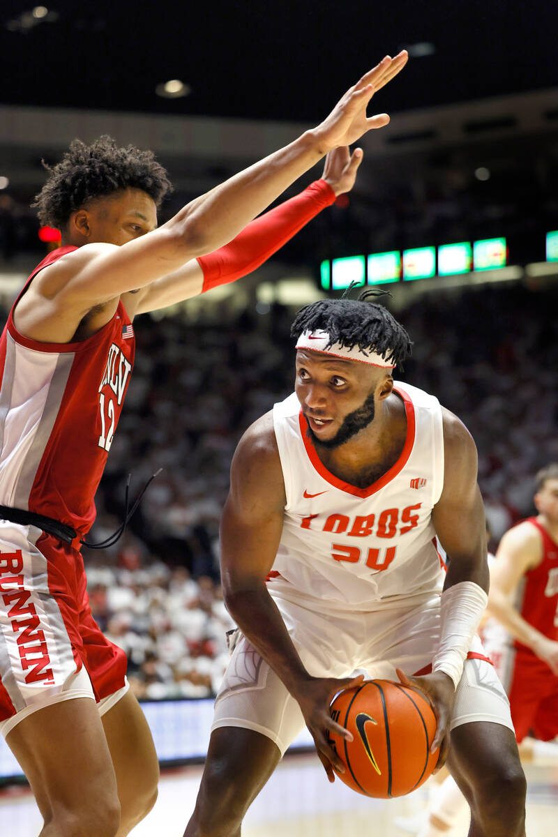 New Mexico's Morris Udeze looks to score a basket as UNLV's David Muoka defends in the second h ...