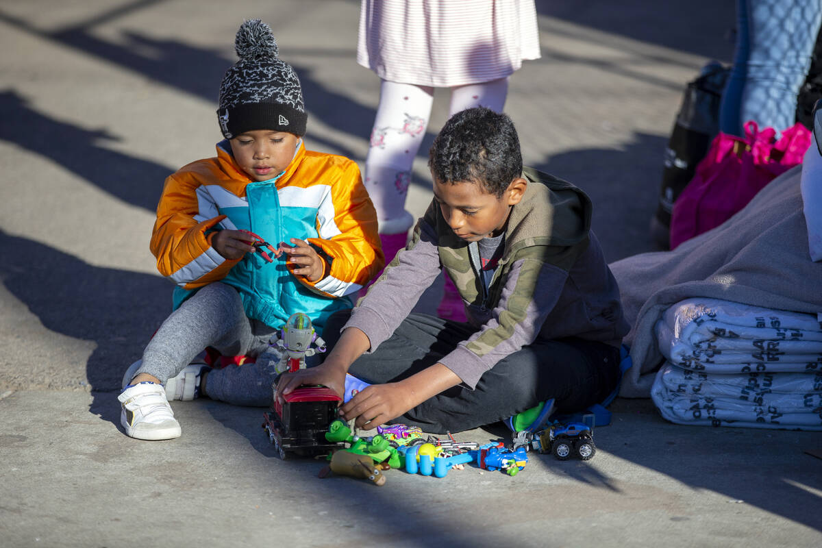 Two migrant kids play with donated toys while camping outside the Sacred Heart Church in downto ...