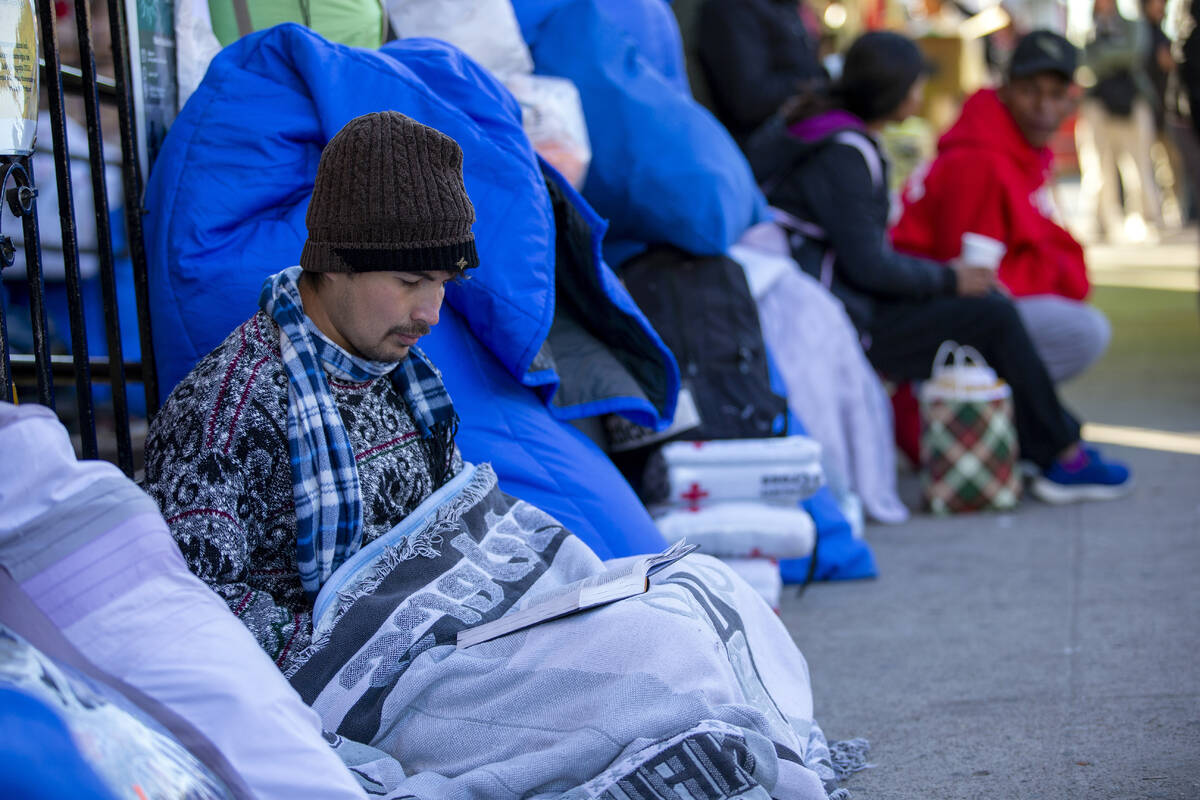 A migrant reads the Bible while camping outside the Sacred Heart Church in downtown El Paso, Te ...