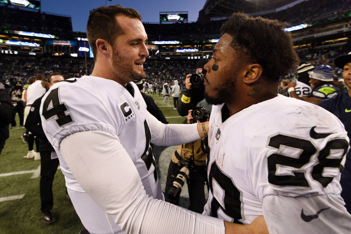 Las Vegas Raiders quarterback Derek Carr (4) celebrates with running back Josh Jacobs (28) afte ...