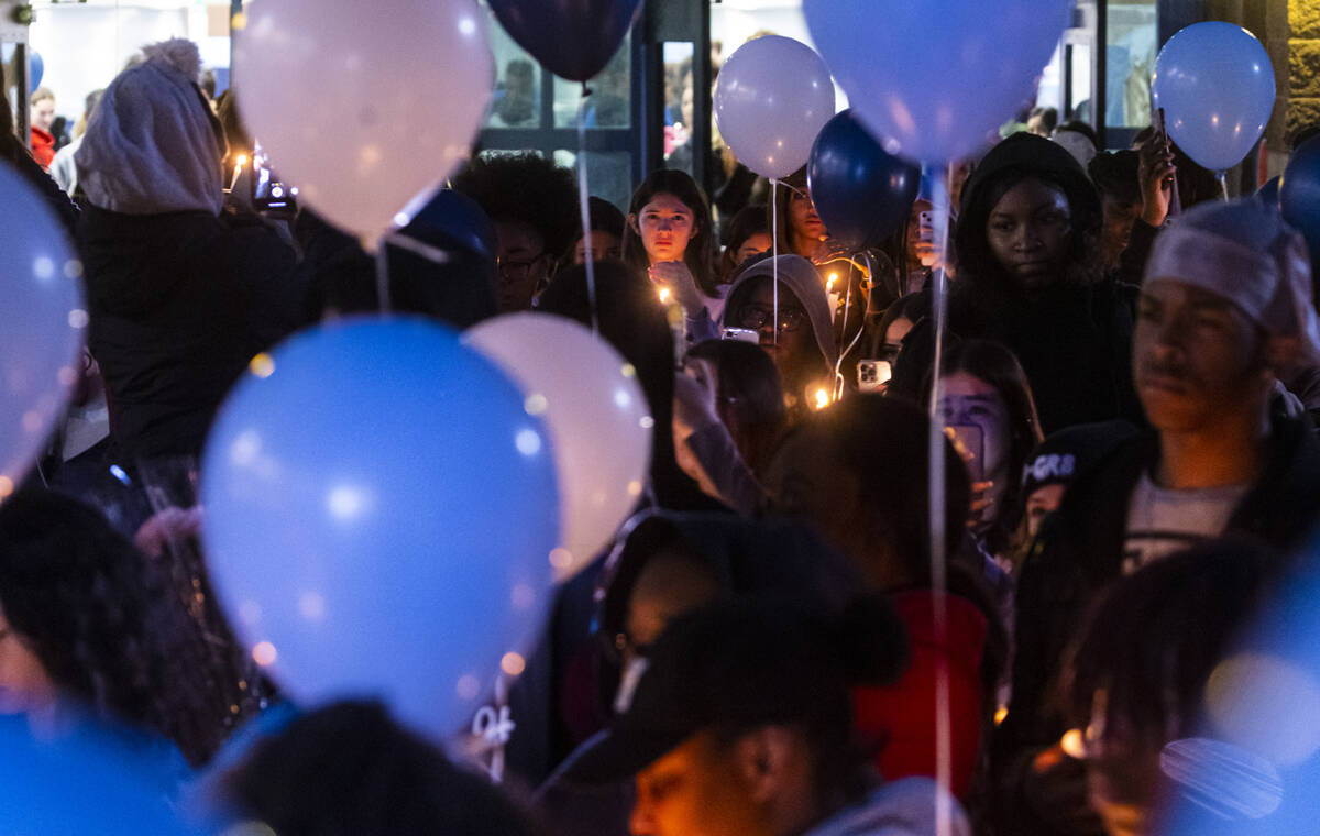 Friends and family of Ashari Hughes, 16, hold candles during a celebration of her life at Cente ...