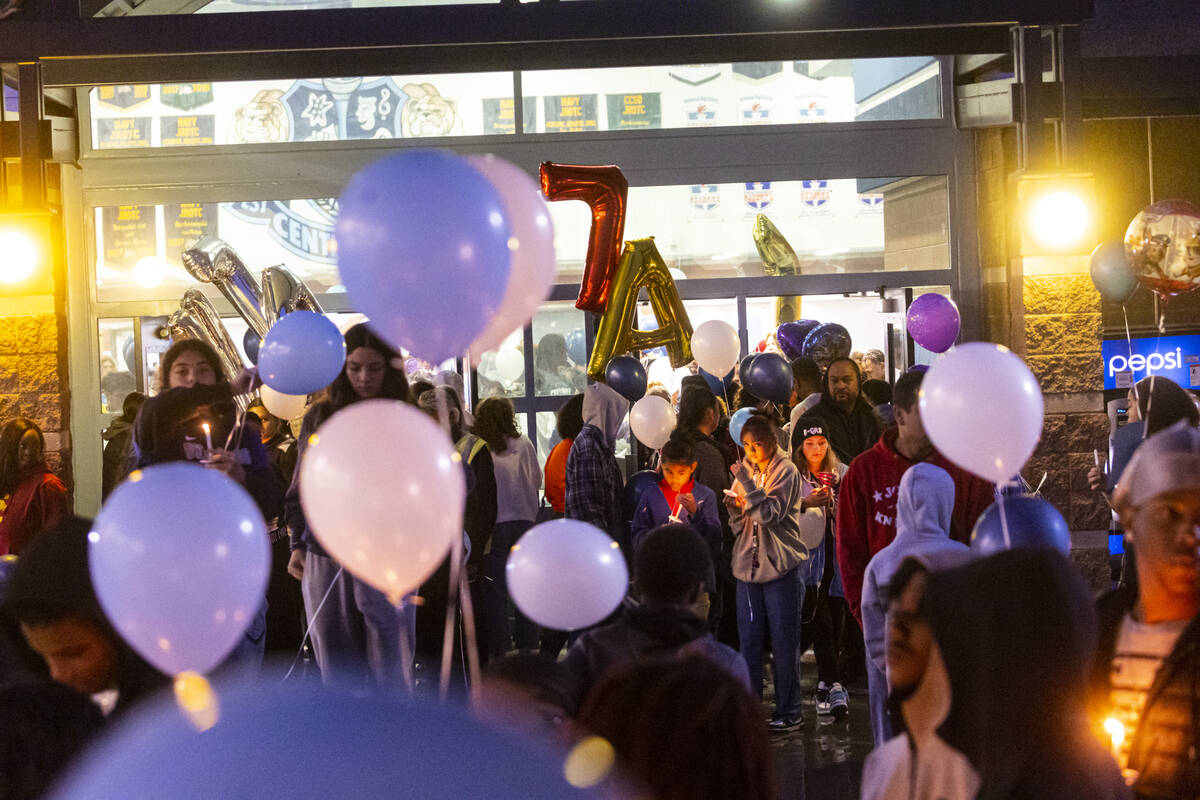 Friends and family of Ashari Hughes, 16, hold candles during a celebration of her life at Cente ...